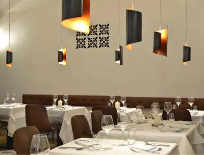a restaurant with white tables and chairs with wine glasses at Hotel Maribor & Garden Rooms in Maribor