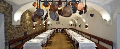 a row of tables in a room with pots and pans at Hotel Maribor & Garden Rooms in Maribor