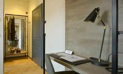 a desk with a lamp and a book on it at Hotel Maribor & Garden Rooms in Maribor