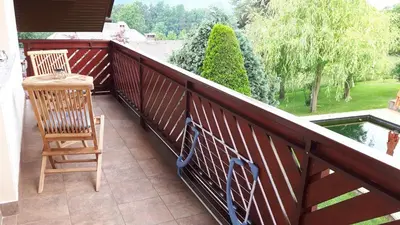a balcony with two chairs and a table and a pond at Apartments Magdalena in Radovljica