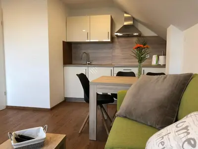 a kitchen and living room with a table and a couch at Apartments Magdalena in Radovljica