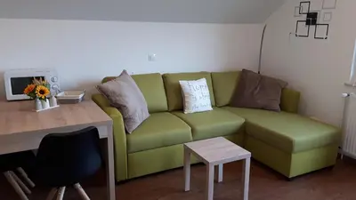 a living room with a green couch and a table at Apartments Magdalena in Radovljica