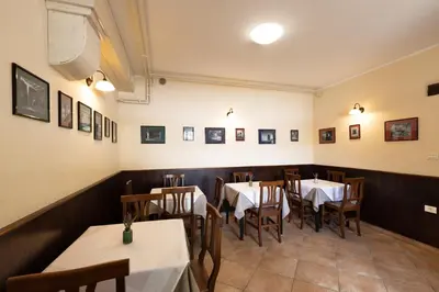 a dining room with tables and chairs and pictures on the walls at Kraška hiša Škrla in Divača