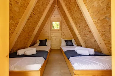 two beds in a room in a log cabin at Kraška hiša Škrla in Divača