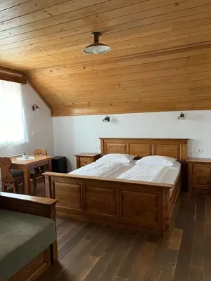 a large bed in a room with a wooden ceiling at Šport center Prodnik in Ljubno