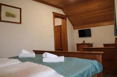 a bedroom with two beds and a flat screen tv at Šport center Prodnik in Ljubno