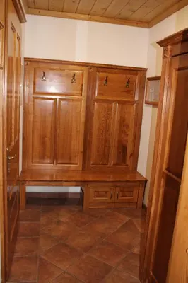 a kitchen with wooden cabinets and a tile floor at Šport center Prodnik in Ljubno