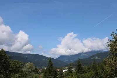 a view of a mountain range with trees and clouds at Šport center Prodnik in Ljubno