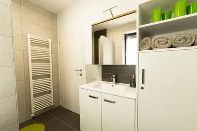 a white bathroom with a sink and a mirror at Apartma Mariposa Banovci in Banovci