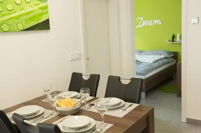 a dining room with a table and chairs and a bed at Apartma Mariposa Banovci in Banovci