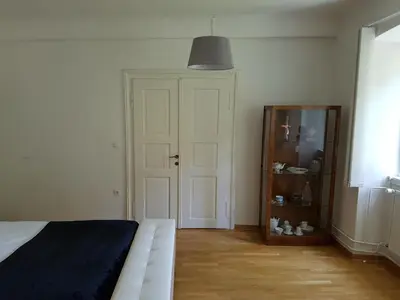 a bedroom with a white bed and a mirror at SIPPO Apartments in Ljubljana