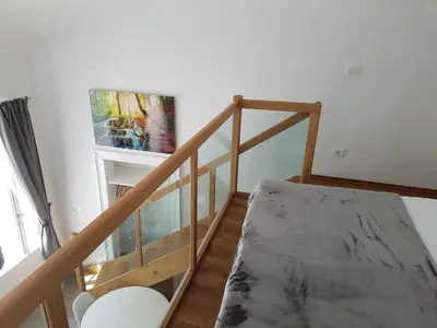a room with a staircase with a table and a window at SIPPO Apartments in Ljubljana