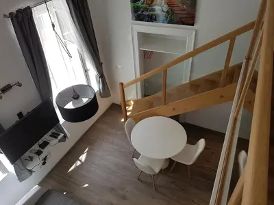 a white table and chairs in a room with a staircase at SIPPO Apartments in Ljubljana