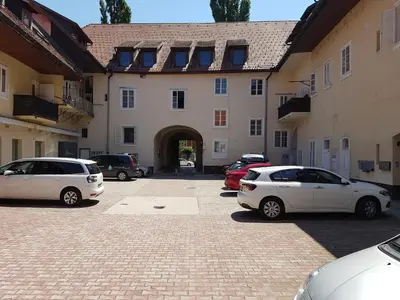 a parking lot with cars parked in front of a building at SIPPO Apartments in Ljubljana