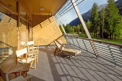 a balcony with chairs and a view of the mountains at Špik Alpine Resort in Kranjska Gora
