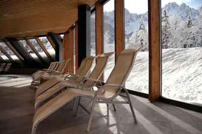 a row of chairs in a room with a snowy mountain at Špik Alpine Resort in Kranjska Gora