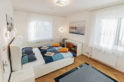 a white bedroom with a bed and a fireplace at Vila Marija in Ljubljana