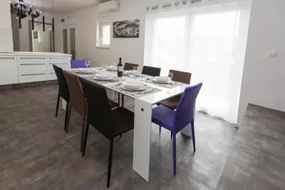 a dining room table with chairs and a bottle of wine at Vila Marija in Ljubljana