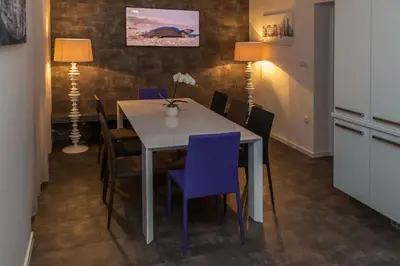 a dining room with a white table and purple chairs at Vila Marija in Ljubljana
