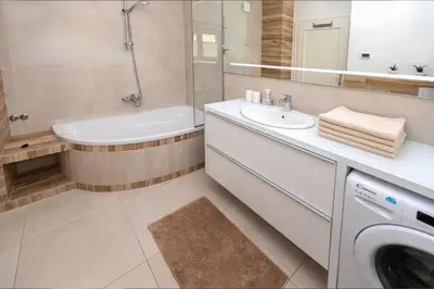 a bathroom with a sink and a washing machine at Vila Marija in Ljubljana