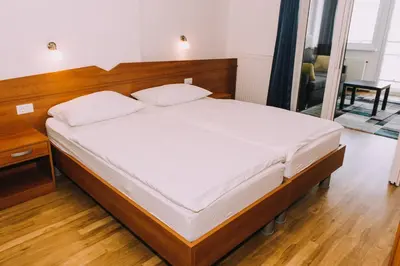 a bedroom with a large bed with a wooden headboard at Hotel Bellevue in Kranj