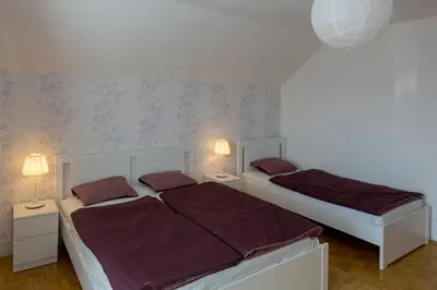 a bedroom with two beds and two lamps on the wall at Vacation Home Sofia in Zgornje Gorje