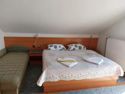 a bedroom with a bed and a couch at Apartmaji Tisa in Moravske Toplice