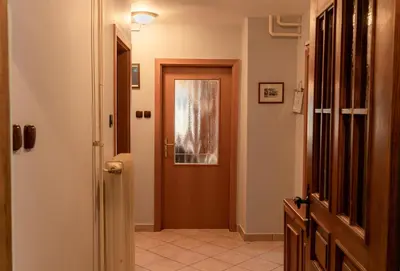 a hallway with a brown door and a tile floor at Apartma Gaby in Bled