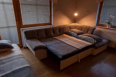 a large couch in a room with a bed at Apartma Gaby in Bled