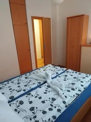a bed with a black and white comforter on it at Apartment Stella in Dolenjske Toplice