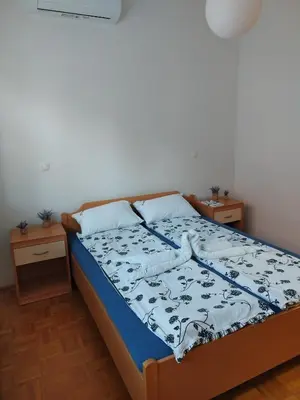 a bedroom with a bed with a blue and white comforter at Apartment Stella in Dolenjske Toplice