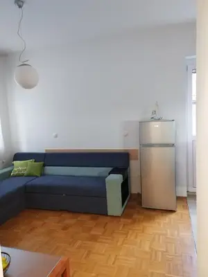 a living room with a blue couch and a kitchen at Apartment Stella in Dolenjske Toplice