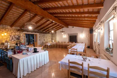 a large room with tables and chairs in a building at Farm Stay Malovščevo in Vitovlje