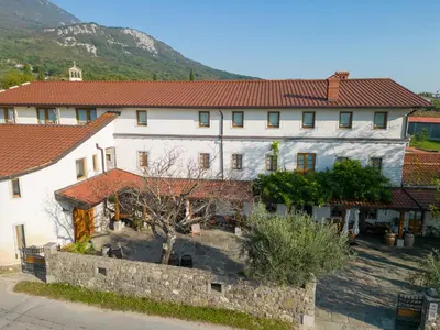 a large white building with red tile roofs at Farm Stay Malovščevo in Vitovlje