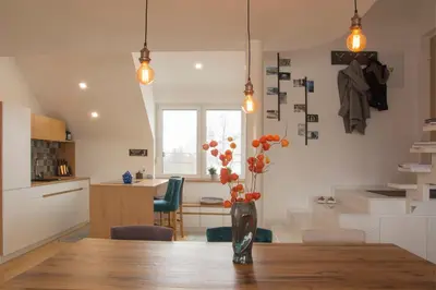 a kitchen and dining room with a vase with flowers on a table at Vintage Design Apartment in Gornja Radgona