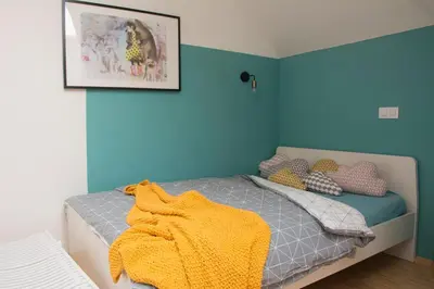 a bedroom with a bed with a yellow blanket on it at Vintage Design Apartment in Gornja Radgona