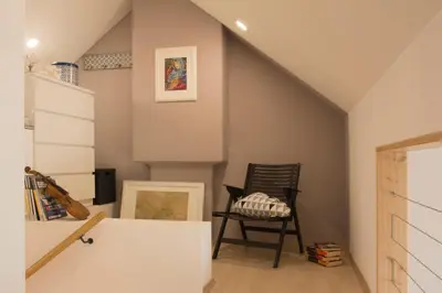 an attic room with a chair and a staircase at Vintage Design Apartment in Gornja Radgona