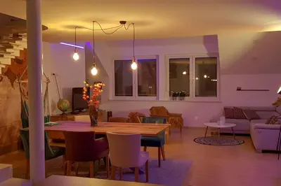 a dining room and living room with a table and chairs at Vintage Design Apartment in Gornja Radgona