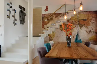 a dining room with a table and a staircase at Vintage Design Apartment in Gornja Radgona