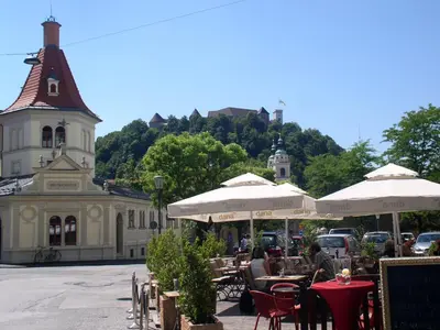 a restaurant with tables and umbrellas in front of a building at Spacious central studio Nika 2 Tour As Ljubljana in Ljubljana