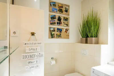 a bathroom with a toilet and some pictures on the wall at Apartmaji BANONIA 