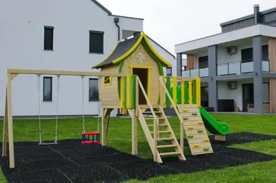 a playground with a slide and a house at Apartmaji BANONIA 