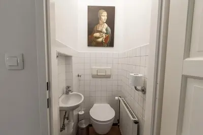 a small bathroom with a toilet and a sink at River and Castle View Apartment Rose Tour As Ljubljana in Ljubljana