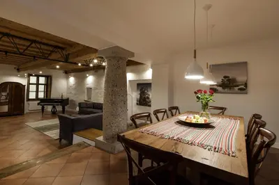 a dining room and living room with a table and chairs at River and Castle View Apartment Rose Tour As Ljubljana in Ljubljana