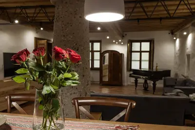 a vase of roses on a table with a piano at River and Castle View Apartment Rose Tour As Ljubljana in Ljubljana