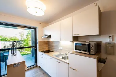 a kitchen with white cabinets and a microwave at Apartmaji BANONIA 