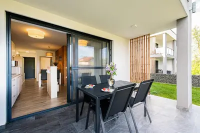 a dining room with a black table and chairs at Apartmaji BANONIA 