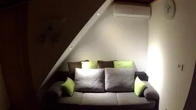 a living room with a couch with pillows in a attic at KRESNIČKA in Čatež ob Savi