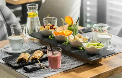 a table with a tray of breakfast foods and drinks at Apartments Sunrise Banovci in Banovci