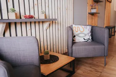 a living room with two chairs and a table at Apartments Sunrise Banovci in Banovci